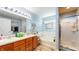 Well-lit bathroom featuring a double vanity, bathtub, and shower with glass doors at 4618 Angelica Dr, Indianapolis, IN 46237