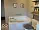 This bathroom features a built-in tub, toilet, towel bar, and shelving at 4823 S State Road 75, Jamestown, IN 46147