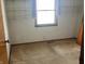 This is a vacant bedroom with carpet and window with curtains and shelves at 4823 S State Road 75, Jamestown, IN 46147