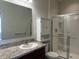 A bathroom with a single sink vanity, storage cabinet, and a glass shower enclosure at 4889 Lilium Dr, Plainfield, IN 46168