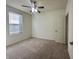 This carpeted bedroom is brightly lit by a window and features a ceiling fan at 4889 Lilium Dr, Plainfield, IN 46168