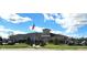 A well-maintained community clubhouse with manicured lawns and an American flag waving proudly under a partly cloudy sky at 4889 Lilium Dr, Plainfield, IN 46168