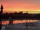 The community pool reflecting a vibrant sunset and offering a peaceful ambiance at 4889 Lilium Dr, Plainfield, IN 46168