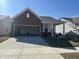 Home exterior showcasing brick accents, an attached garage, and green lawn at 4889 Lilium Dr, Plainfield, IN 46168