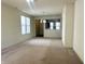 A living room has neutral carpeting with a window and view into the dining area at 4889 Lilium Dr, Plainfield, IN 46168