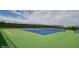A fenced outdoor tennis court on a clear day with vibrant green and blue surfaces ready for play at 4889 Lilium Dr, Plainfield, IN 46168