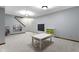 Carpeted basement features a small table with chairs, chalkboard, organizer unit and book shelf under stairs at 4978 St Charles Pl, Carmel, IN 46033