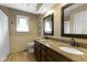 Bathroom features a double sink vanity with granite countertop, tiled walls, and wood look flooring at 4978 St Charles Pl, Carmel, IN 46033