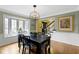 This bright dining room features wainscotting, hardwood floors, modern chandelier, and a large bay window at 4978 St Charles Pl, Carmel, IN 46033