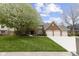 Charming brick home featuring a three-car garage, green lawn, and blooming tree at 4978 St Charles Pl, Carmel, IN 46033