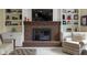 Comfortable living room features a brick fireplace, built-in shelves and neutral-toned decor at 4978 St Charles Pl, Carmel, IN 46033