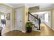 Inviting foyer with hardwood floors, staircase with black railing, and decorative plant at 4978 St Charles Pl, Carmel, IN 46033