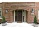 Elegant front door with brick surround, side lights, wreath, and potted plants at 4978 St Charles Pl, Carmel, IN 46033