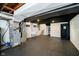Unfinished basement area with painted walls, black ceiling, utility sink, and black tiled flooring at 536 W 52Nd St, Indianapolis, IN 46208