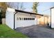Spacious detached garage with white siding, black trim, and an attached driveway on a sunny day at 536 W 52Nd St, Indianapolis, IN 46208