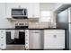 Modern kitchen featuring stainless steel appliances, white cabinets, and a sleek black countertop at 536 W 52Nd St, Indianapolis, IN 46208