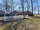 Quaint home with a white picket fence and a glimpse of the brick house beyond the trees at 551 E 600 S, Lebanon, IN 46052