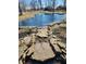 Beautiful view of a pond with decorative statue, landscaping, and a glimpse of the house at 551 E 600 S, Lebanon, IN 46052