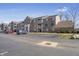 Wide view of the condominium building exterior, parking lot, and well-maintained landscaping at 6525 Emerald Hill Ct # 207, Indianapolis, IN 46237