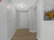 Bright foyer with wood-look floors, a white entry door, and a view of the kitchen at 6525 Emerald Hill Ct # 207, Indianapolis, IN 46237