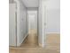 Hallway with multiple doorways, wood-look flooring, and neutral paint throughout the home at 6525 Emerald Hill Ct # 207, Indianapolis, IN 46237