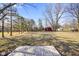 Expansive backyard featuring a red barn, mature trees, and open green space, perfect for outdoor activities at 6603 Iona Rd, Indianapolis, IN 46203
