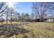Spacious backyard featuring mature trees, a red barn, and plenty of open space, ideal for recreation at 6603 Iona Rd, Indianapolis, IN 46203