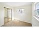 Bright bedroom with mirrored closet doors, a window, and neutral carpet at 6603 Iona Rd, Indianapolis, IN 46203