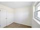 Cozy bedroom featuring neutral carpet, a window, and door with white trim at 6603 Iona Rd, Indianapolis, IN 46203