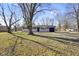 Inviting single-story home with a well-manicured lawn, gray brick facade, and attached garage on a sunny day at 6603 Iona Rd, Indianapolis, IN 46203