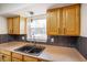 A kitchen sink with a modern faucet set below a window with overhead cabinets and stylish backsplash at 6603 Iona Rd, Indianapolis, IN 46203