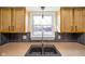 Kitchen sink and countertop area with overhead cabinets, complemented by stylish backsplash and natural light at 6603 Iona Rd, Indianapolis, IN 46203