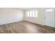 Bright living room featuring wood-look floors, a front door, a large window, and freshly painted walls at 6603 Iona Rd, Indianapolis, IN 46203