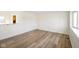 Open living area with wood-look floors, pass-through window to the kitchen, and ample natural light at 6603 Iona Rd, Indianapolis, IN 46203