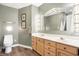Stylish bathroom featuring a double vanity with wood cabinets, modern fixtures, and decorative mirror at 6655 Gopher Dr, Nineveh, IN 46164