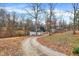 Gravel driveway leading to a dome-style home with a detached garage, enveloped by trees and lush landscape at 6655 Gopher Dr, Nineveh, IN 46164