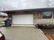 This is a two car garage with a concrete driveway in front of the doors and stone around the windows at 721 Stover Ave, Indianapolis, IN 46227