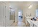 Bright primary bathroom with double sinks, a shower, and an open doorway to the bedroom at 7256 Firestone Rd, Whitestown, IN 46075