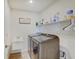 Functional laundry room with modern washer and dryer, sink, and shelving for storage at 7256 Firestone Rd, Whitestown, IN 46075