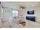Spacious living room with large sectional sofa, ceiling fan, and abundant natural light at 7256 Firestone Rd, Whitestown, IN 46075