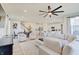 Bright, open-concept living area with a large sectional sofa, hardwood floors, and modern ceiling fan at 7256 Firestone Rd, Whitestown, IN 46075