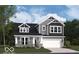 Charming two-story home with stone accents, gray siding, and a covered porch at 7310 Raybourn Ct, Indianapolis, IN 46259