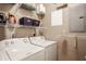 Functional laundry room with white appliances and ample shelving for storage, ideal for organization at 802 N Meridian St # 103, Indianapolis, IN 46204