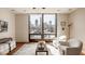 Bright living room with large windows offering city views, comfortable seating, and stylish decor at 802 N Meridian St # 103, Indianapolis, IN 46204