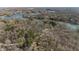 This aerial view of the mature community has bare trees and dense woods around waterfront properties at 8172 S Shoreview Dr, Trafalgar, IN 46181