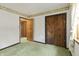Bedroom with olive green carpet, decorative wallpaper, and view of hallway with multiple doors at 8172 S Shoreview Dr, Trafalgar, IN 46181