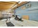 Well-lit garage with a blue accent wall and an exposed rafter ceiling at 8172 S Shoreview Dr, Trafalgar, IN 46181