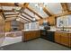 This kitchen has wooden cabinets, black appliances, and leads to a living space with a brick fireplace at 8172 S Shoreview Dr, Trafalgar, IN 46181