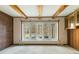Living room area with brick wall, beamed ceiling, large window, and wood built-ins at 8172 S Shoreview Dr, Trafalgar, IN 46181