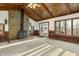 Living room with stone fireplace, wood ceiling, and ample natural light from multiple windows at 8172 S Shoreview Dr, Trafalgar, IN 46181
